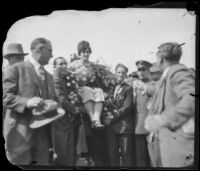 Aimee Semple McPherson is hoisted into the air upon her arrival, Los Angeles, 1926