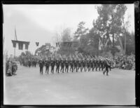 Marching soldiers carrying rifles followed by color guard in the Tournament of Roses Parade, Pasadena, 1930 in the Tournament of Roses Parade, Pasadena, 1931