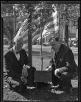 D. A. Russell and Dr. Herbert S. Johnson pose with a plaque dedicated to Benny the squirrel, Los Angeles, 1935