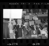 Richard Nixon clasping hands with Ronald Reagan and Senator George Murphy at Republican rally in Anaheim, Calif., 1970