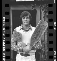 Curtis Creath of UCLA's Beta Theta Pi fraternity, holding pledge paddles, 1979