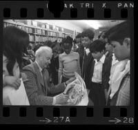 Bill Peet, children's book illustrator and writer autographing Hubert the Lion drawing for school children in Los Angeles, Calif., 1974