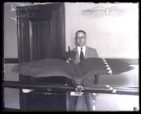 Wayland Avery with J. H. Montgomery's model airplane with wings designed like bird's wings, Los Angeles, 1930