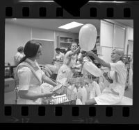 Group of Las Madrinas debutantes blowing up balloons for patients at Childrens Hospital in Los Angeles, Calif., 1970