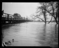 Norwalk bridge spanning the San Gabriel River swollen with rainstorm flooding, [Norwalk?], 1927