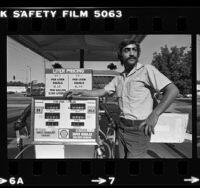 Gas station employee, Steve Farah standing next to metric gas pump in Los Angeles, Calif., 1980