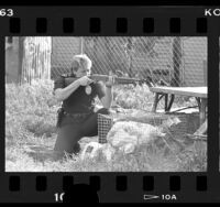 Police officer Cheryl Kent with shotgun aimed at home during raid in South Los Angeles, Calif., 1986