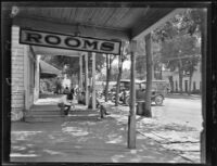 Men sitting under awnings before storefronts, Big Pine, 1927