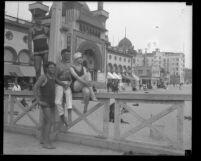 Bathers and lifeguard on boardwalk in front of the Ocean Park Bathhouse at Venice Beach, circa 1925