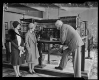 Sir Nevile R. Wilkinson shows off his dollhouse, "Titania's Palace," to Miss Katherine L. Howes[?] and Mrs. Franklin A.[?] Howe, Jr., Los Angeles, 1928