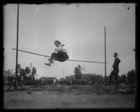 Woman high-jumper attempting to clear the bar, Los Angeles, circa 1920