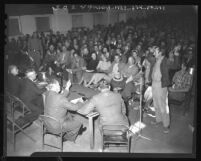 August H. Betsy, Antelope Valley farmer with Bible in hand, protests zoning plan at meeting of Los Angeles Planning Commission, 1948