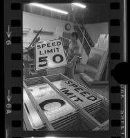 Safeway Sign Company employee Gil Plazola stacking "Speed Limit 50" signs in Gardena, Calif., 1973