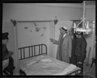 Detective Lieutenant Frank R. Harper points to damage from bombing at Lyndon Foster's home, Los Angeles, 1935