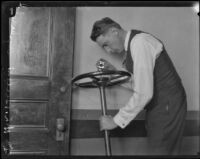 Los Angeles police sergeant Howard L. Barlow inspecting a car steering wheel, Los Angeles, 1927