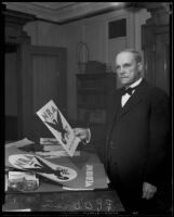 Postmaster P. P. O'Brien holds a poster for the NRA (National Recovery Administration), Los Angeles, 1933