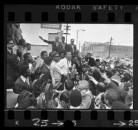 Congressman Adam Clayton Powell, surrounded by crowd and reporters during tour of Watts, Calif., 1968