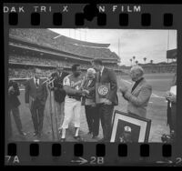 Hank Aaron receiving honors from Tom Bradley, Ernest Debs and John Ferraro before Braves vs Dodgers game, Calif., 1974