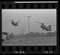 Helicopters land next to a fire engine in a parking lot near Century Plaza during President Johnson's visit, 1967