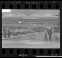 Police and civilians await the arrival of President Johnson at the Pavillion Shops in Century City, 1967