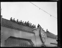 Rose Parade spectators on the roof of the Hupmobile dealer building on W. Colorado Blvd., Pasadena, 1930