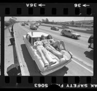 Three teenagers sunbathing on the hood of their stalled car on shoulder of Santa Monica Freeway, Los Angeles, 1980