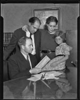 Archie Carter, Gladys Carter, and Virginia Carter look over some paperwork with Attorney Donald MacKay, Los Angeles, 1935