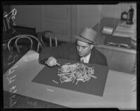 Detective Lieutenant Henry H. Perry examines confiscated drugs, Los Angeles, 1939