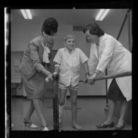 John Marcum, 9, being aided by doctors during hemophilia rehabilitation, 1965