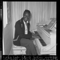Singer Nat King Cole playing piano at his home in Los Angeles, Calif., 1964