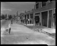 Workers clearing brick rubble from a sidewalk after the Long Beach earthquake, Southern California, 1933