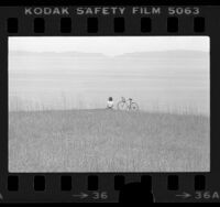 Cyclist Tammy Murray sitting on cliff at Portuguese Bend, Calif., 1976