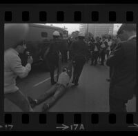 Protester dragged by police on Avenue of the Stars outside of Century Plaza Hotel, where President Johnson is speaking. B. 1967