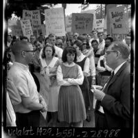 Whittier College president Paul S. Smith talking with student leader Dean Pitts in front of group of student demonstrators, Calif., 1965