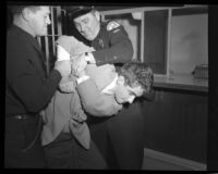Police officers restraining actor Scotty Beckett at jail in Hollywood, Calif., 1948