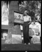 Doris Dalzell admires a painting at an outdoor art gallery, Palm Springs, 1936