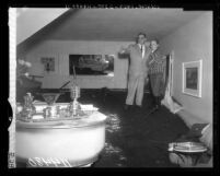 Joseph Whitman shows the damage caused by a mudslide that swept into his home in Benedict Canyon, Calif., 1959