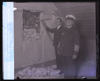 Police officer Ray Cottle and Captain Clem Peoples reveal the old jail cell door, Los Angeles, 1929