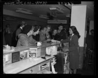 Actors Marsha Hunt, Humphrey Bogart, Lauren Bacall and others at airport ticket counter on way to Washington D.C. to see Un-American Activities Committee