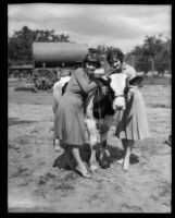 Two young women pose with a cow at the Los Angeles County Fair, Pomona, 1930