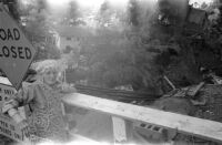 Elsie Bansen stands in front of the remains of her home at Mount Washington, 1969