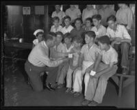 Police Captain W. M. Littell with Stanley Bell and other children from Hollenbeck Heights, Hollenbeck Station, Los Angeles, 1935