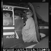 Joan A. Merriam Smith loading plane in preparation for solo around the world flight, Calif., 1964