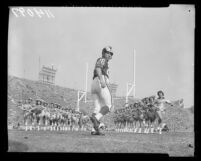 Los Angeles Rams' Jon Arnett running through line of Ramettes, 1958