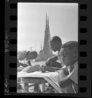 Against the background of the Watts Towers, art instructor Judson Powell with two students 1965