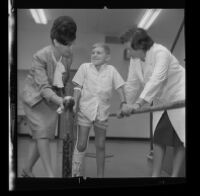 John Marcum, 9, being aided by doctors during hemophilia rehabilitation, 1965