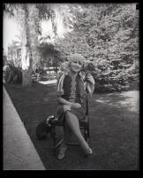 Millicent Sunday seated in a chair in a park or yard, Los Angeles, 1928