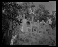 Children who survived the bombing of the headquarters of the Fountain of the World sect pose with an adult member in the ruins of the building. C. 1958