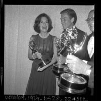 Mary Tyler Moore, Dick Van Dyke, and Sheldon Leonard holding their awards backstage at Emmy Awards, 1964