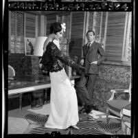 Fashion designer James Galanos with model wearing in one of his gowns, Los Angeles, Calif., 1965